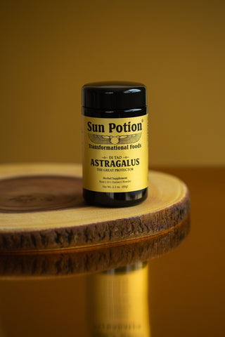Violet glass jar of Sun Potion Astragalus on a wooden stand